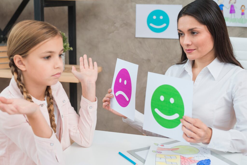 smiling psychologist showing happy sad emotion faces cards girl child 1